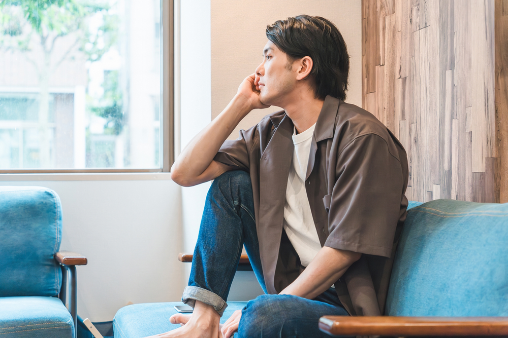 部屋で寂しそうにしている40代男性